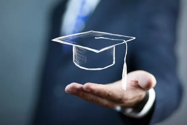 "A man in a suit holds out his hand with a digitally drawn graduation cap